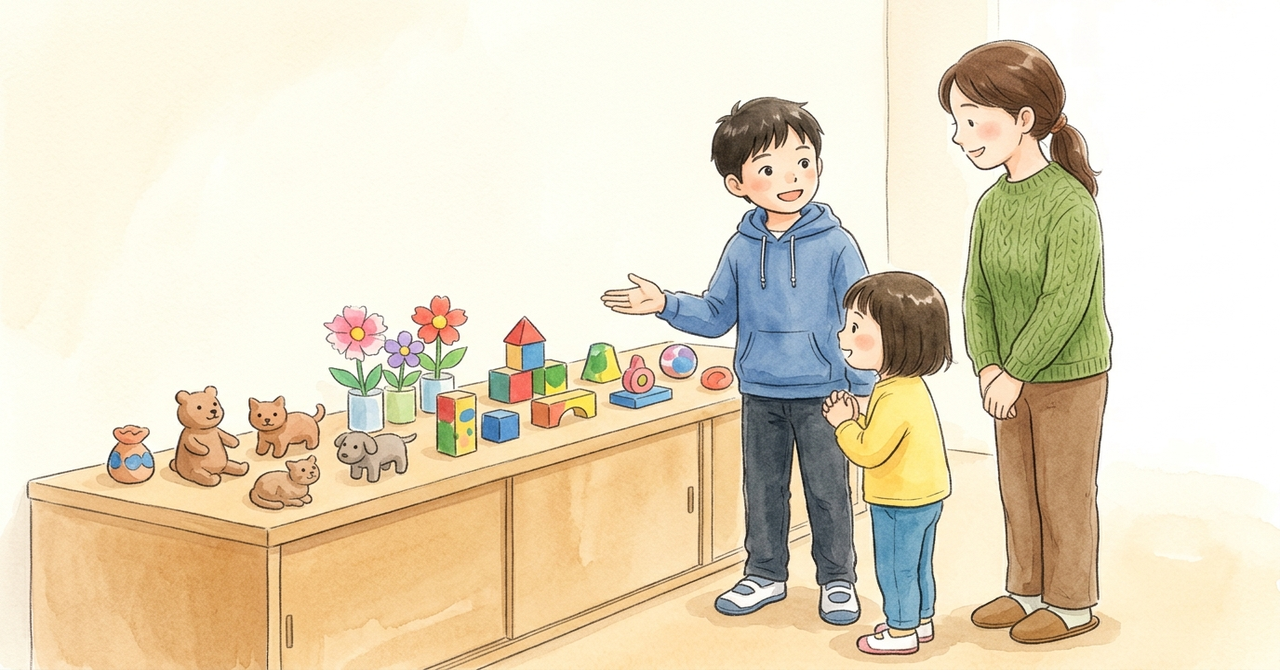 教室の展示台の前で、子どもが小さい子と大人に、それぞれ手で展示を案内している。